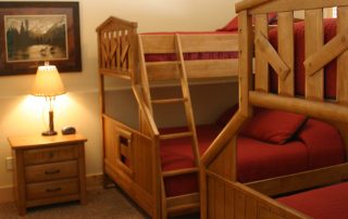 Image of two bed bunks and a night stand with lamp.